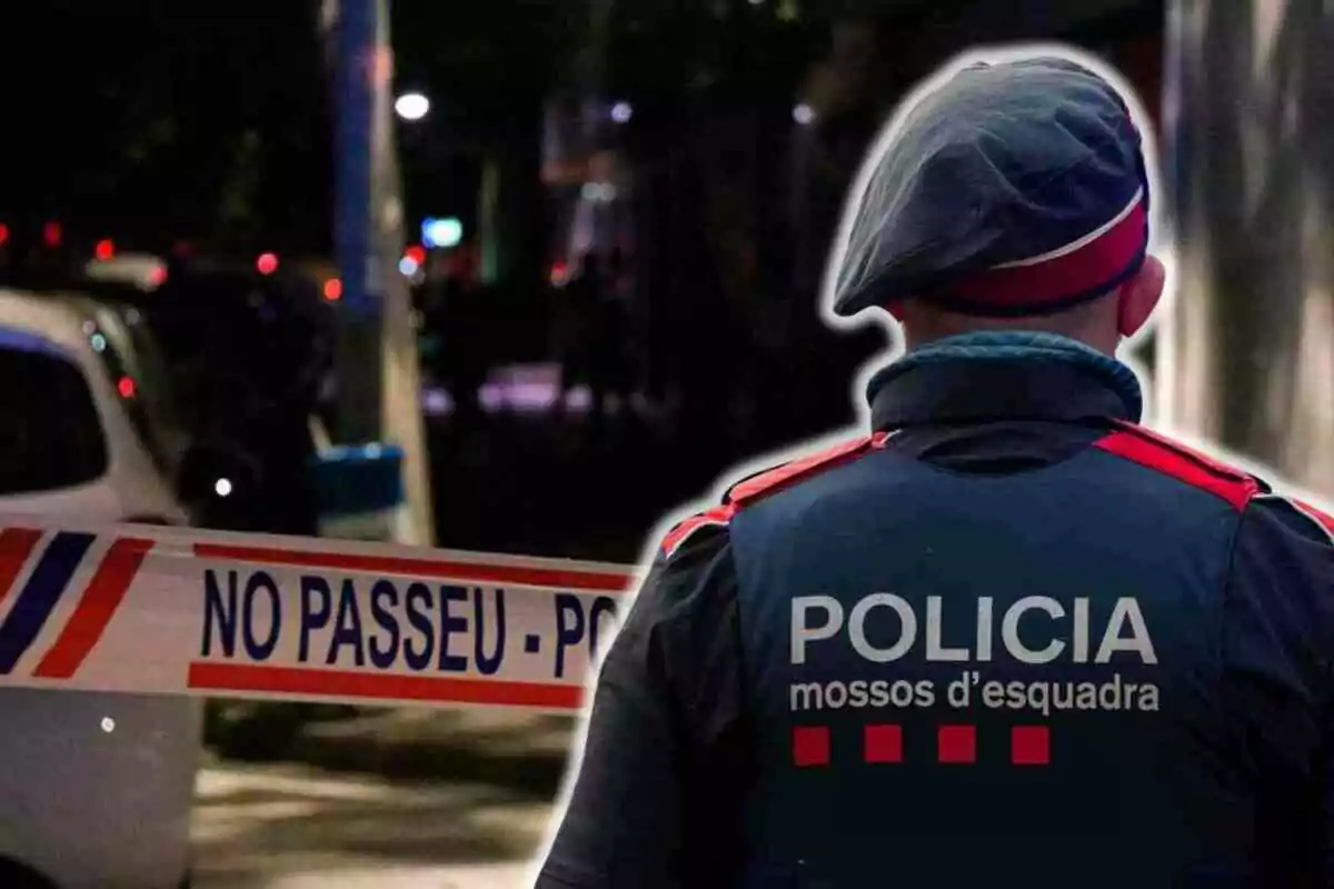 Un agente de policía de los Mossos d'Esquadra de espaldas frente a una cinta de seguridad que dice "NO PASSEU - POLICIA".