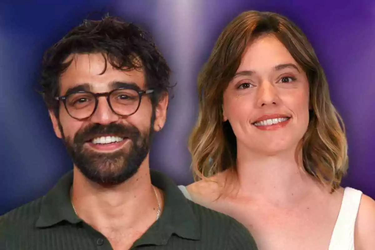 David Verdaguer y María Rodríguez Soto sonrientes posando frente a un fondo difuminado de colores púrpura y azul.