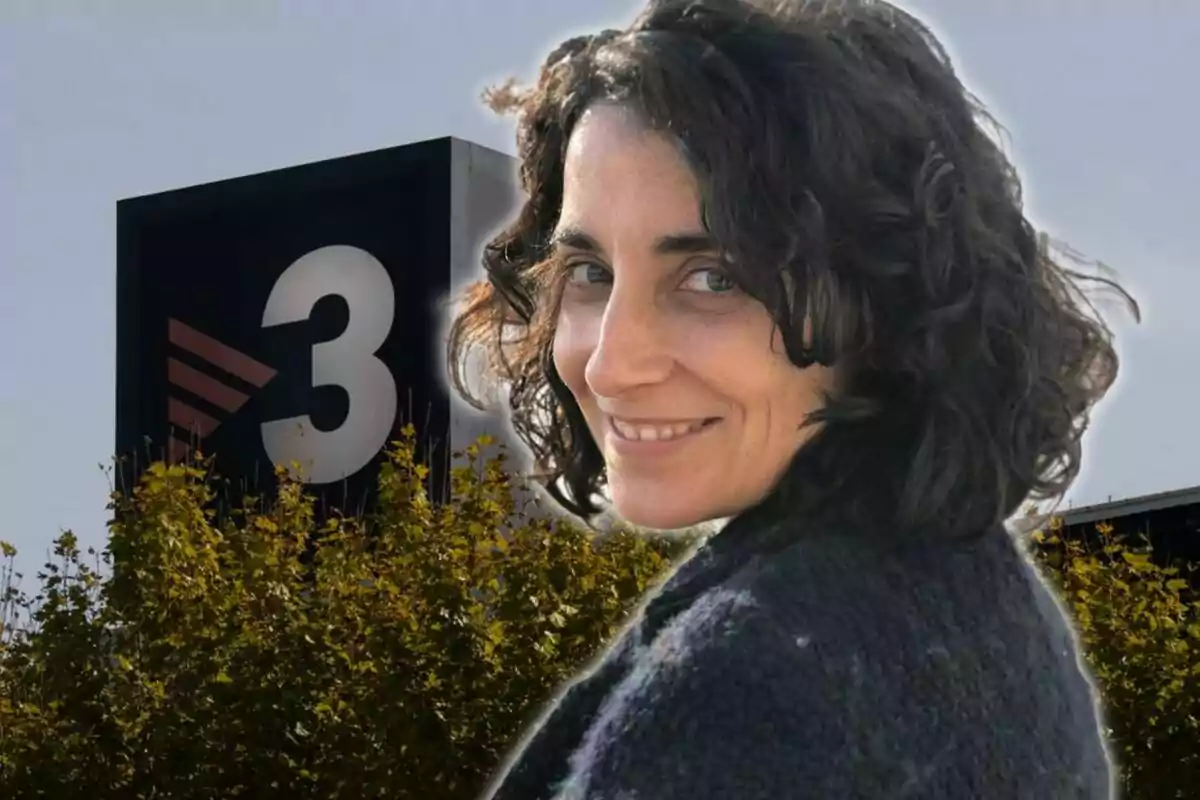 Mujer sonriente con cabello rizado frente a un edificio con el logotipo del número 3.