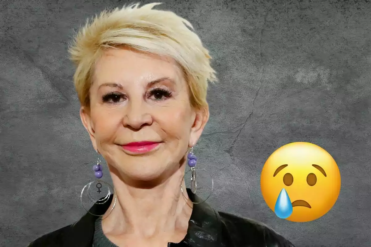 Una mujer de cabello corto y rubio con una expresión neutral, usando aretes grandes y un emoji de cara triste con una lágrima al lado.