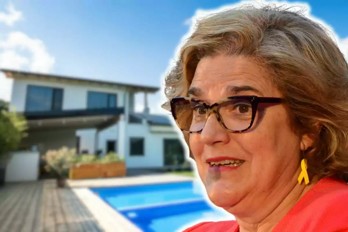 Mujer con gafas y pendientes amarillos frente a una casa moderna con piscina.