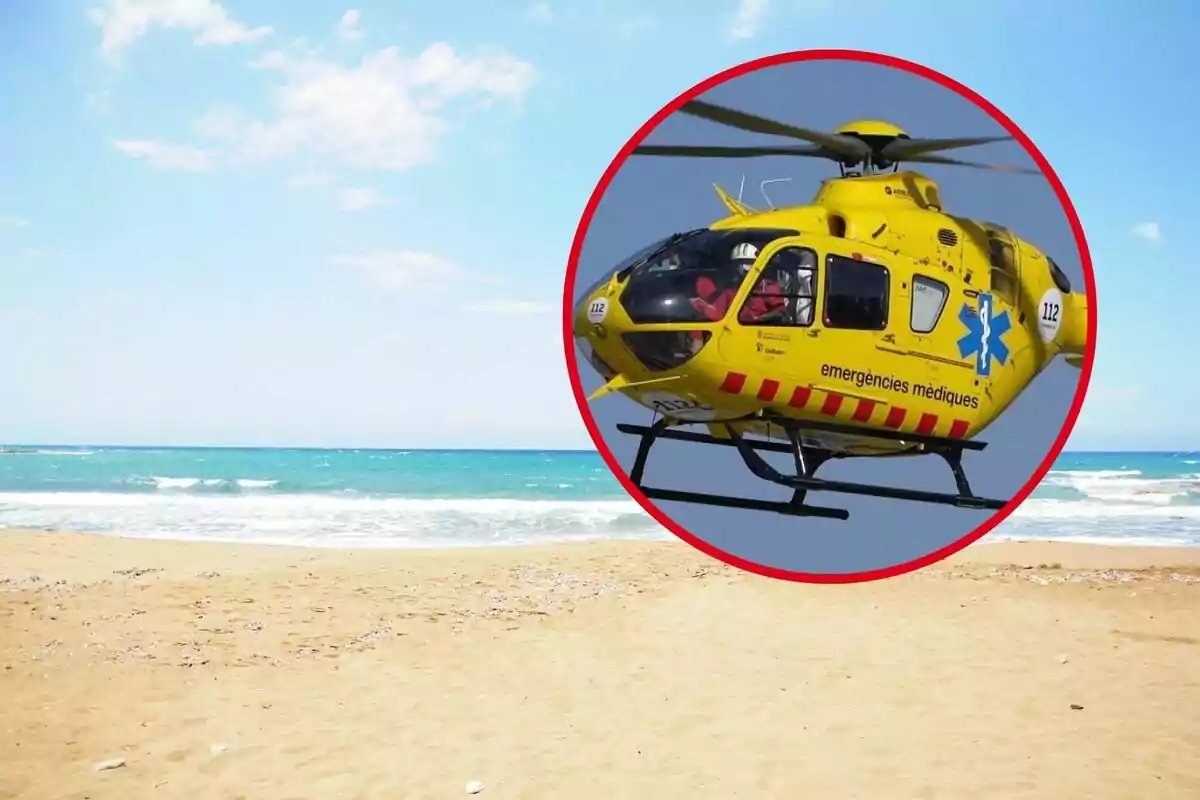 Helicóptero de emergencias médicas sobrevolando una playa con el mar de fondo.