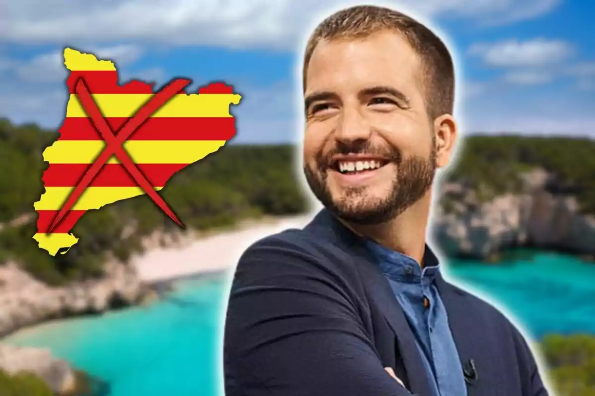 Un hombre sonriente con barba y cabello corto, con un fondo de playa y un mapa de Cataluña con una cruz roja encima.