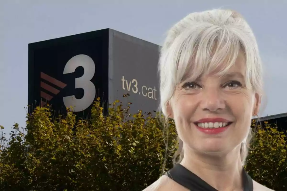 Una mujer sonriente frente al edificio de TV3 con árboles en primer plano.