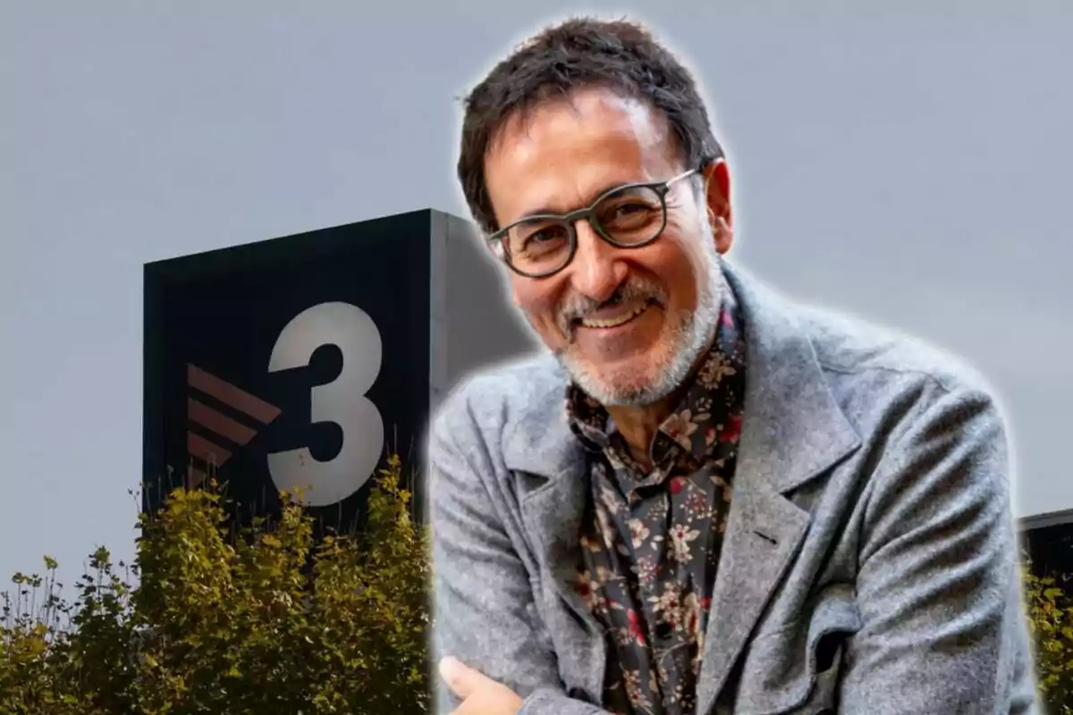 Un hombre con gafas y barba sonríe frente a un edificio con el logotipo de TV3.