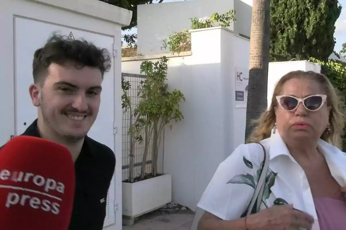 Fran Redondo sonriendo con una camiseta negra junto a Mayte Zaldívar seria con gafas de sol y camisa blanca y un micrófono rojo delante Fran Redondo sonriendo con una camiseta negra junto a Mayte Zaldívar seria con gafas de sol y camisa blanca y un micrófono rojo delante