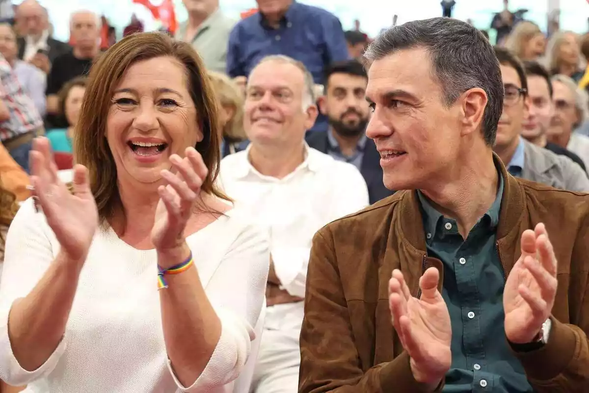 Plano medio de Francina Armengol y Pedro Sánchez riendo y aplaudiendo