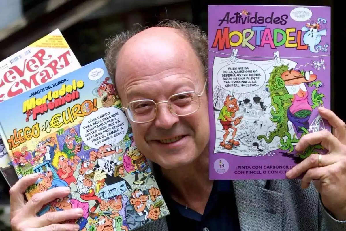 Francisco Ibáñez posando sonriente con sus comics