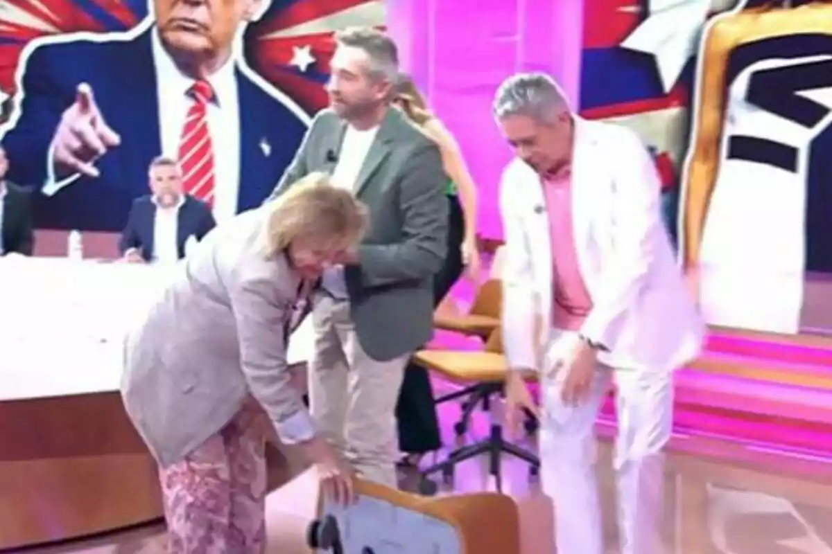 Paloma Barrientos, Frank Blanco y Boris Izaguirre en un set de televisión en Tardear con fondo colorido y una imagen grande de un hombre con traje señalando