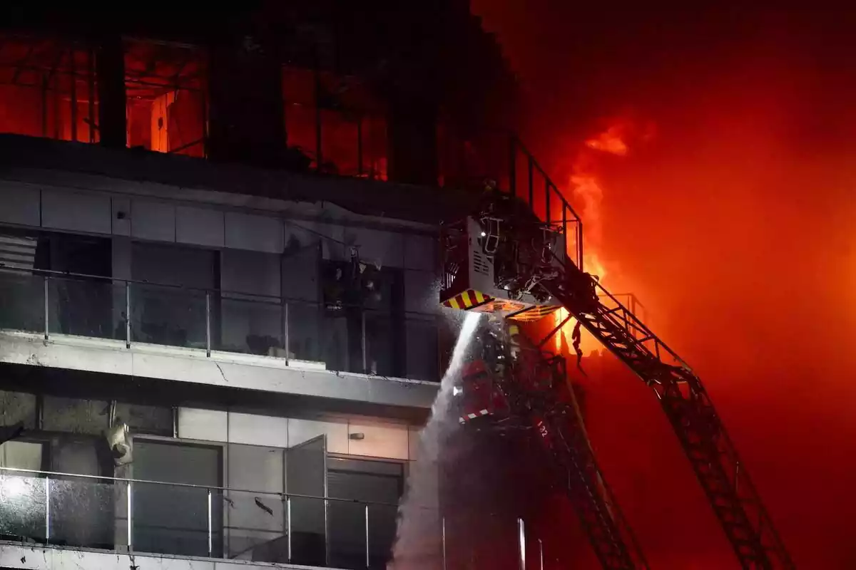 Los bomberos tratan de apagar un incendio en un edificio