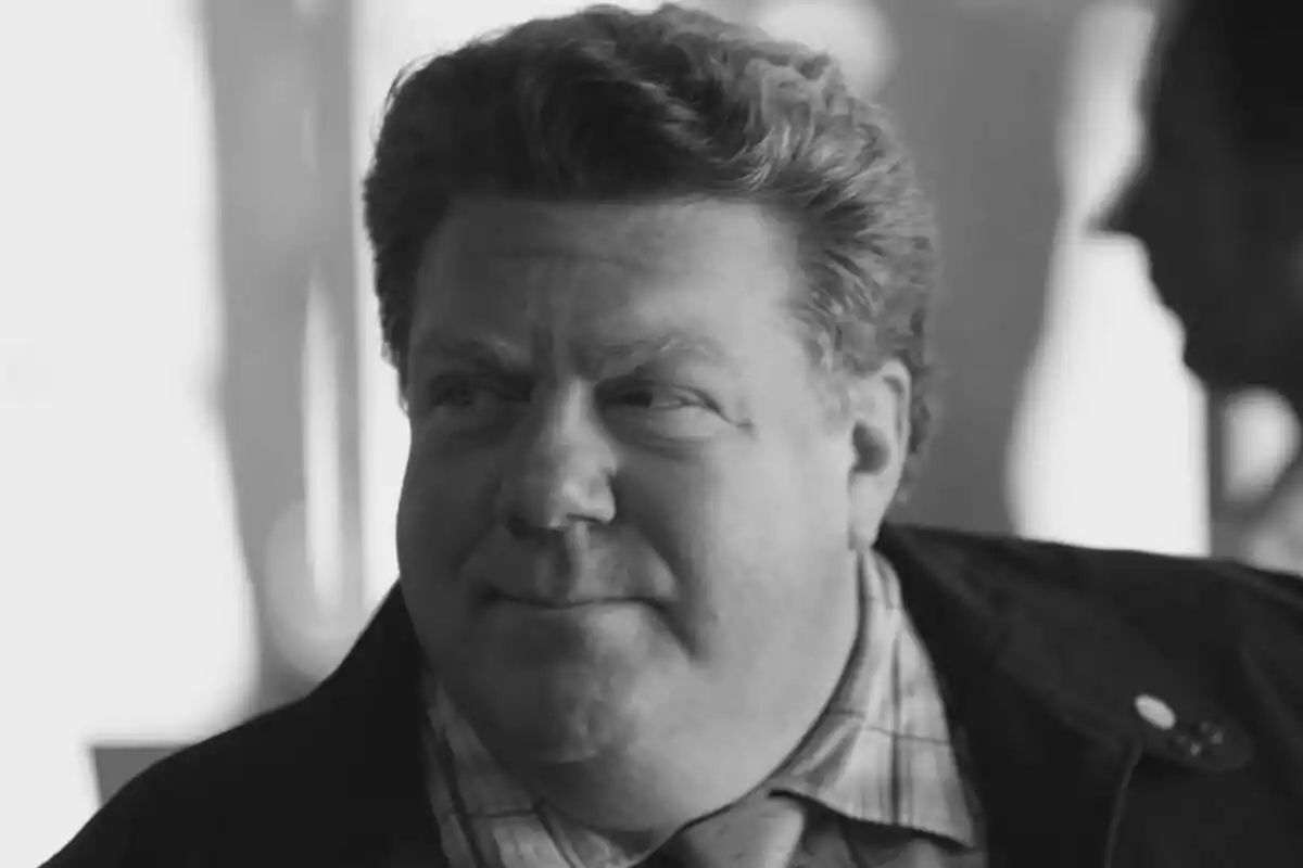 George Wendt de mediana edad con cabello rizado y expresión pensativa en una fotografía en blanco y negro.