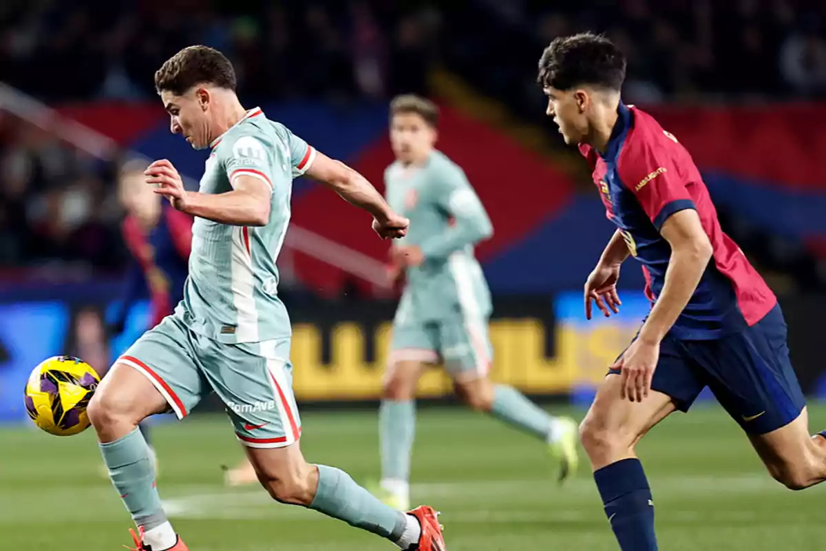 Dos jugadores de fútbol compiten por el balón en un partido. Dos jugadores de fútbol compiten por el balón en un partido.