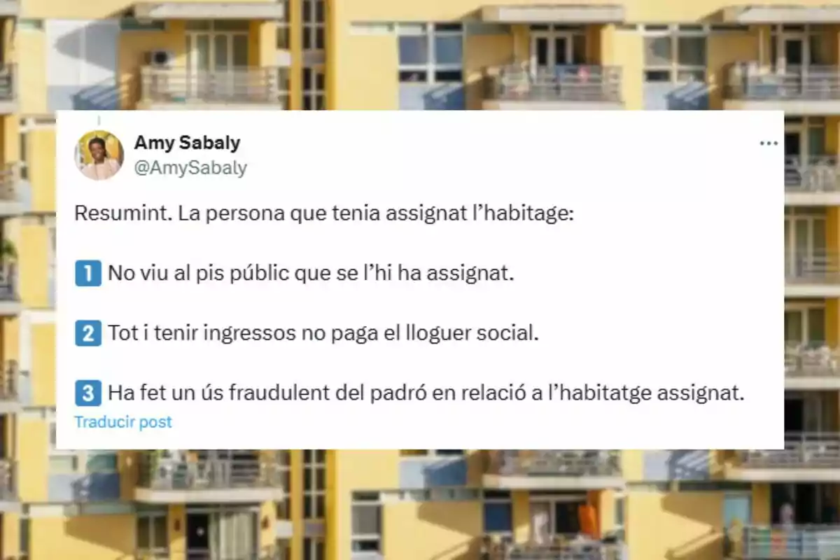 Captura de pantalla de un tuit en catalán sobre el uso indebido de una vivienda pública, con una lista de tres puntos y de fondo un edificio de apartamentos amarillos. Captura de pantalla de un tuit en catalán sobre el uso indebido de una vivienda pública, con una lista de tres puntos y de fondo un edificio de apartamentos amarillos.