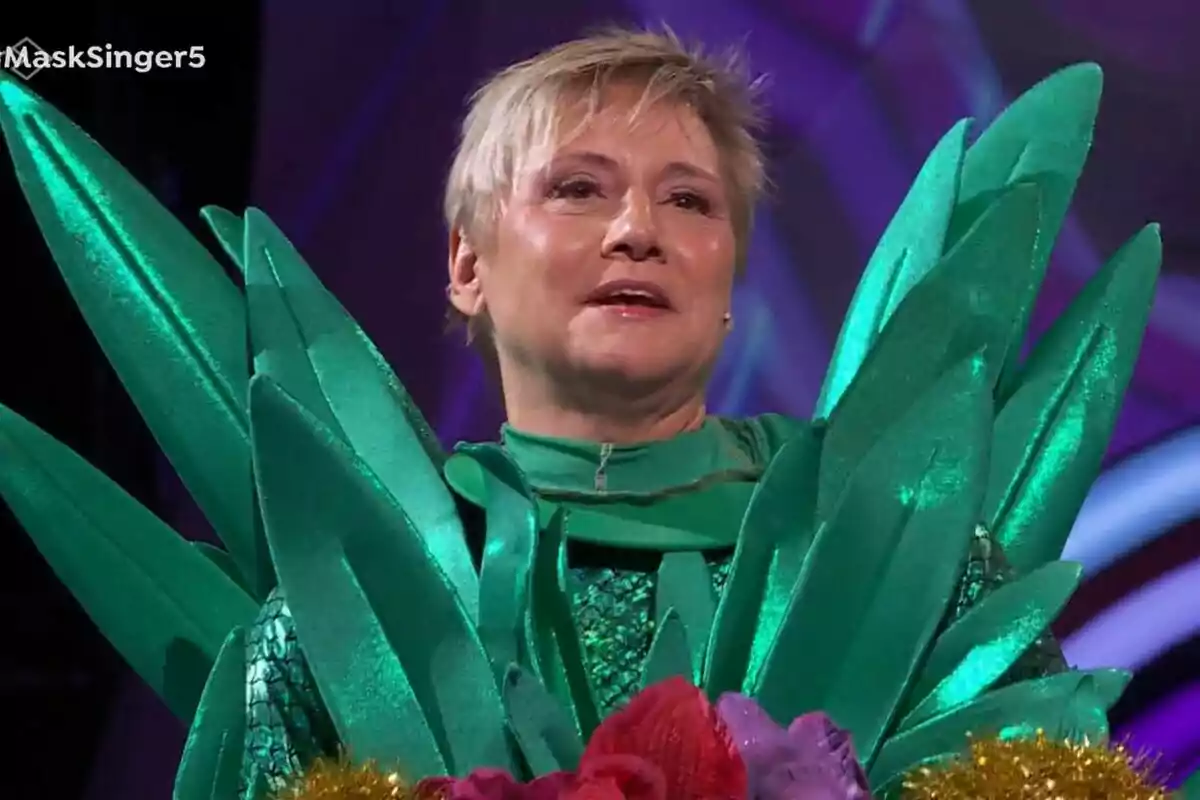 Gloria Serra con un disfraz de piña brillante con detalles en forma de hojas en un escenario de Mask Singer.