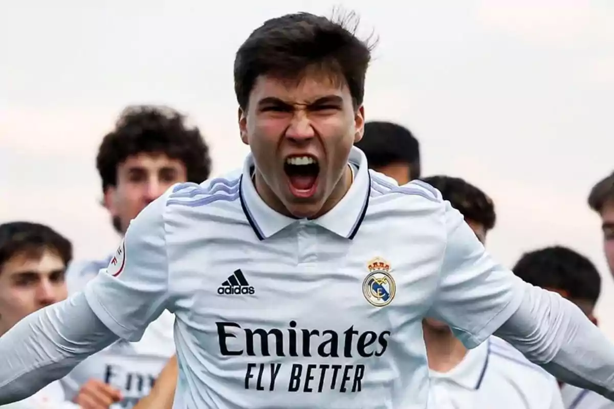 Un jugador de fútbol con la camiseta del Real Madrid celebra con entusiasmo.
