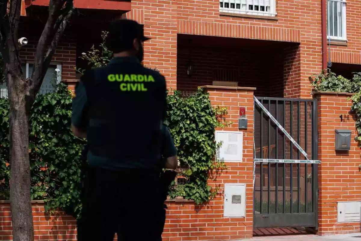 Guardia Civil de espaldas delante de una vivienda