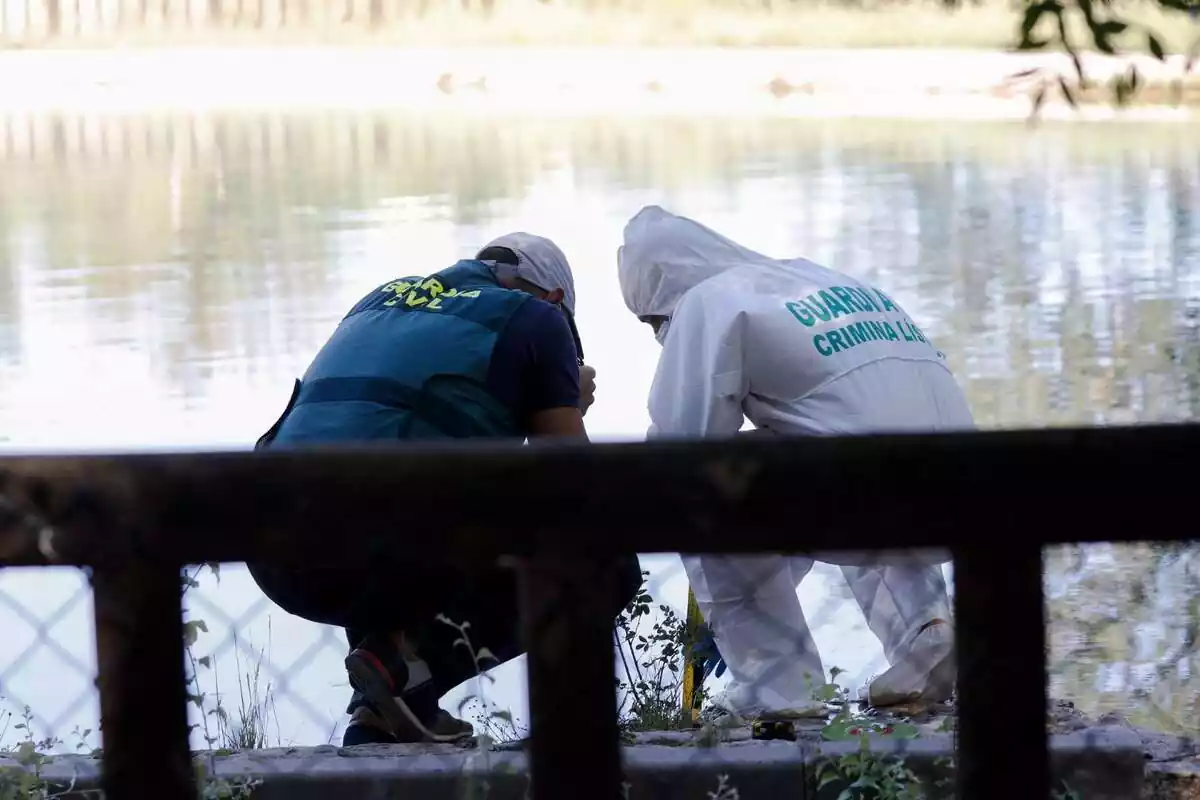 Guardia Civil agachada el borde de un estanque