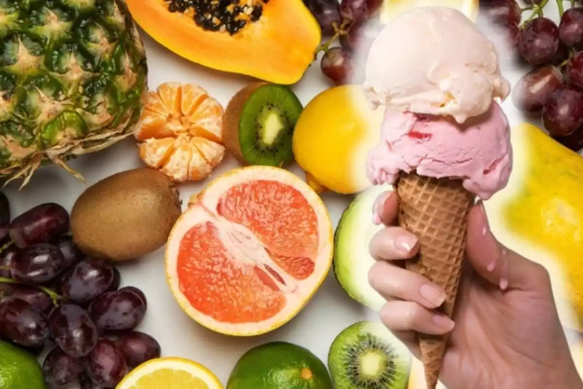 Una mano sosteniendo un helado de dos bolas frente a una variedad de frutas como piña, papaya, kiwi, uvas, limón, toronja y aguacate. Una mano sosteniendo un helado de dos bolas frente a una variedad de frutas como piña, papaya, kiwi, uvas, limón, toronja y aguacate.