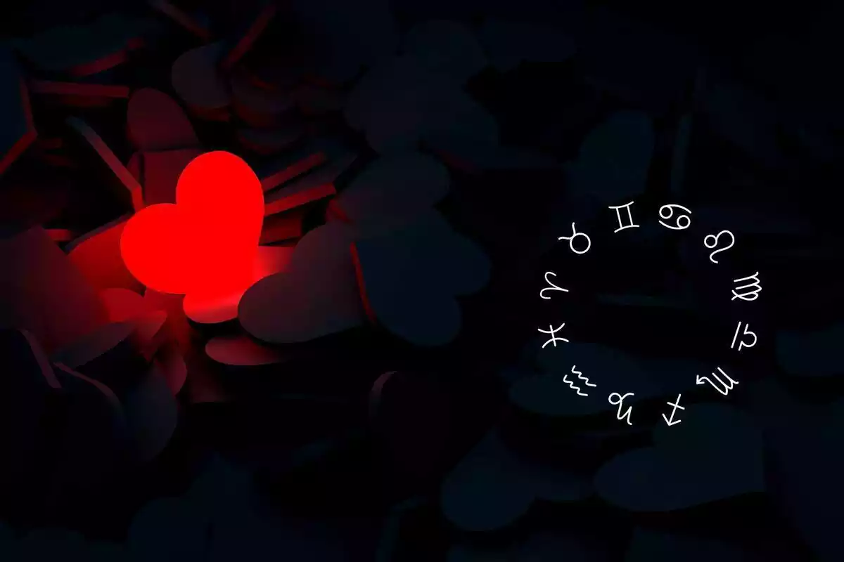 Un corazón rojo iluminado sobre un fondo negro y una rueda zodiacal a su derecha