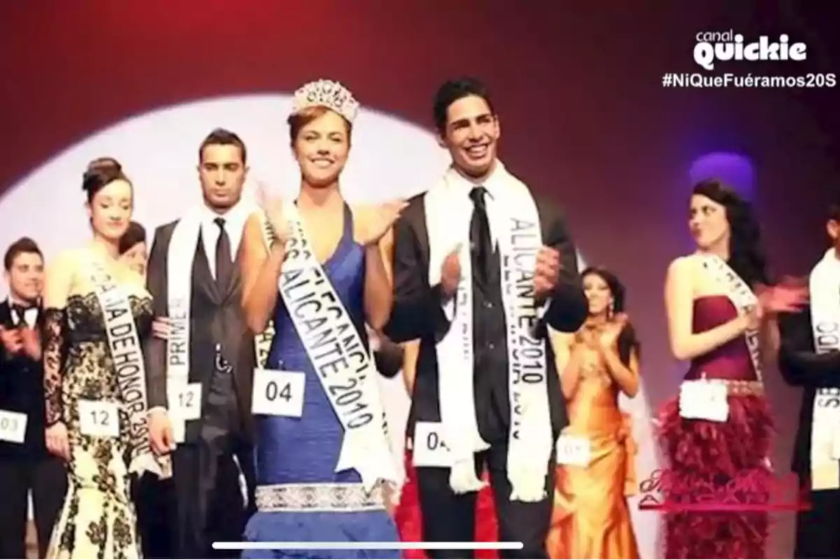 Adara Molinero y un grupo de personas en un escenario, algunas de ellas con bandas que indican títulos de concursos de belleza, como Adara Molinero y un grupo de personas en un escenario, algunas de ellas con bandas que indican títulos de concursos de belleza, como