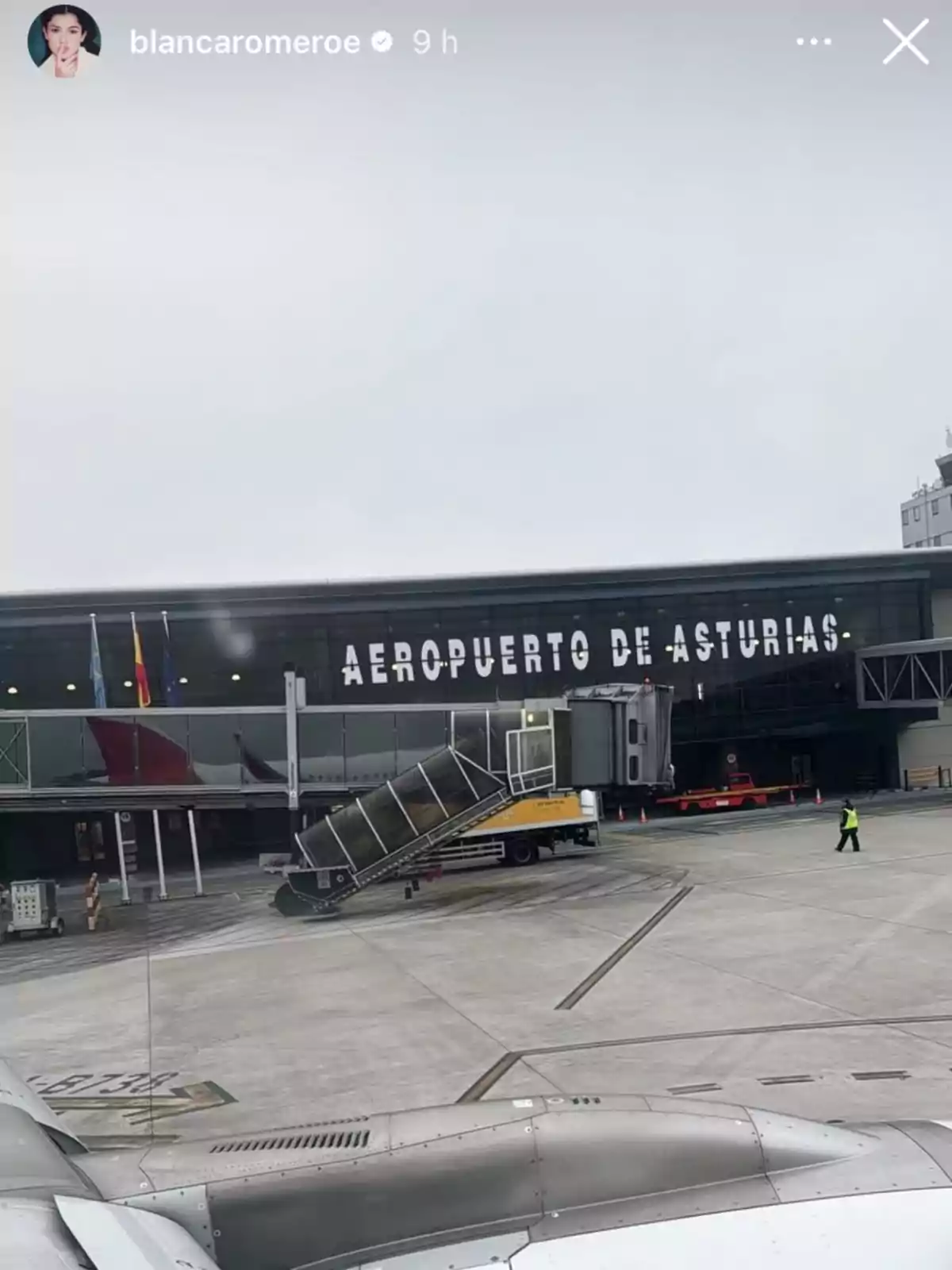 Vista del Aeropuerto de Asturias desde la pista con un avión en primer plano y una pasarela móvil. Vista del Aeropuerto de Asturias desde la pista con un avión en primer plano y una pasarela móvil.