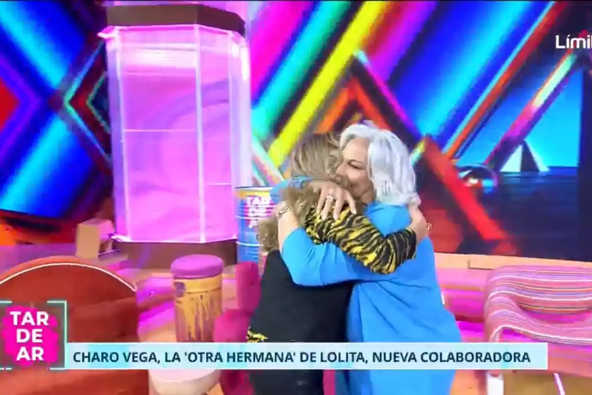 Charo Vega y Lolita Flores se abrazan en un colorido set de televisión. Charo Vega y Lolita Flores se abrazan en un colorido set de televisión.