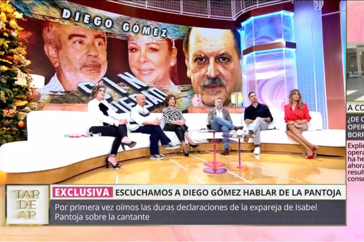 Un grupo de personas sentadas en un plató de televisión con una pantalla grande detrás que muestra imágenes de dos personas y el texto 