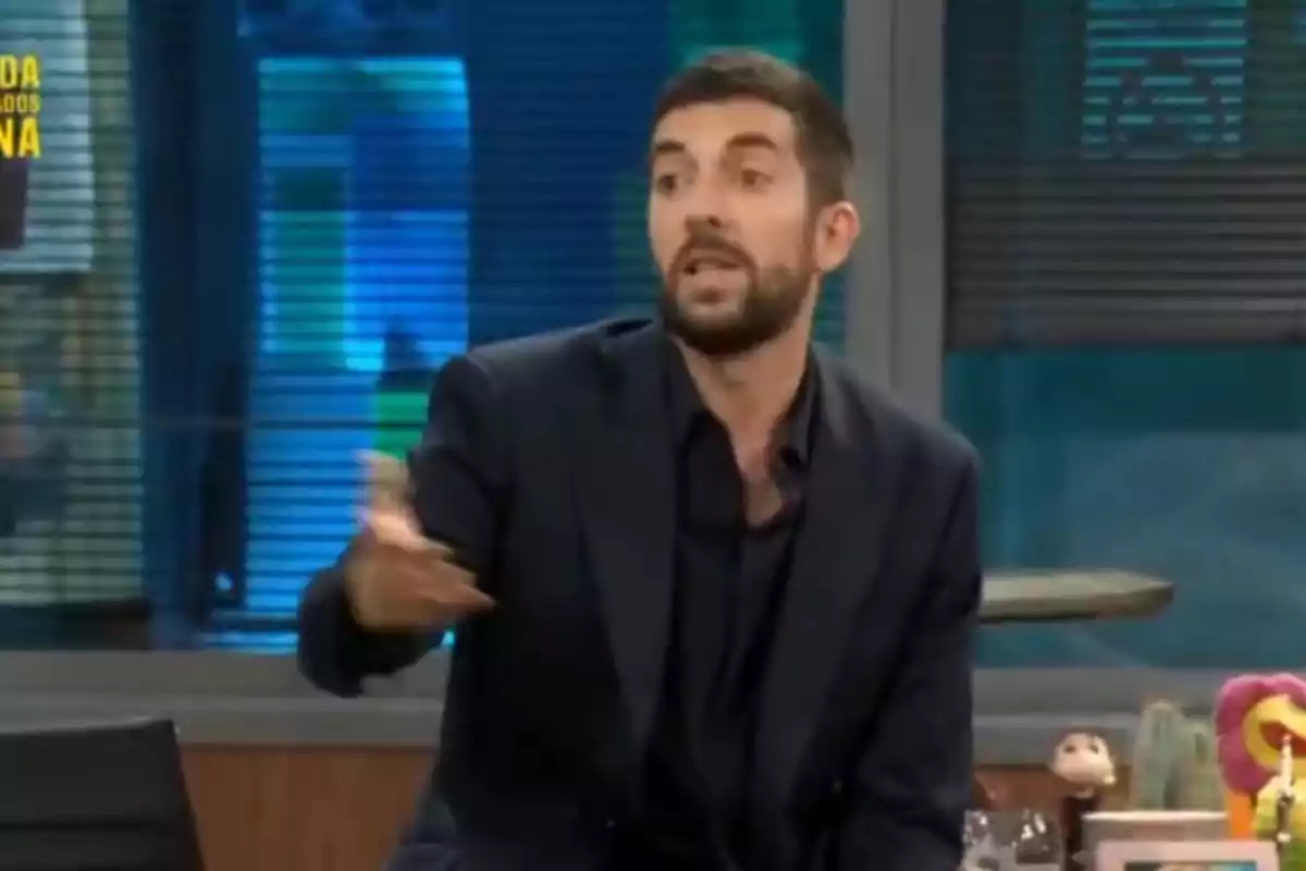 David Broncano con barba y traje oscuro gesticula mientras habla en un programa de televisión.