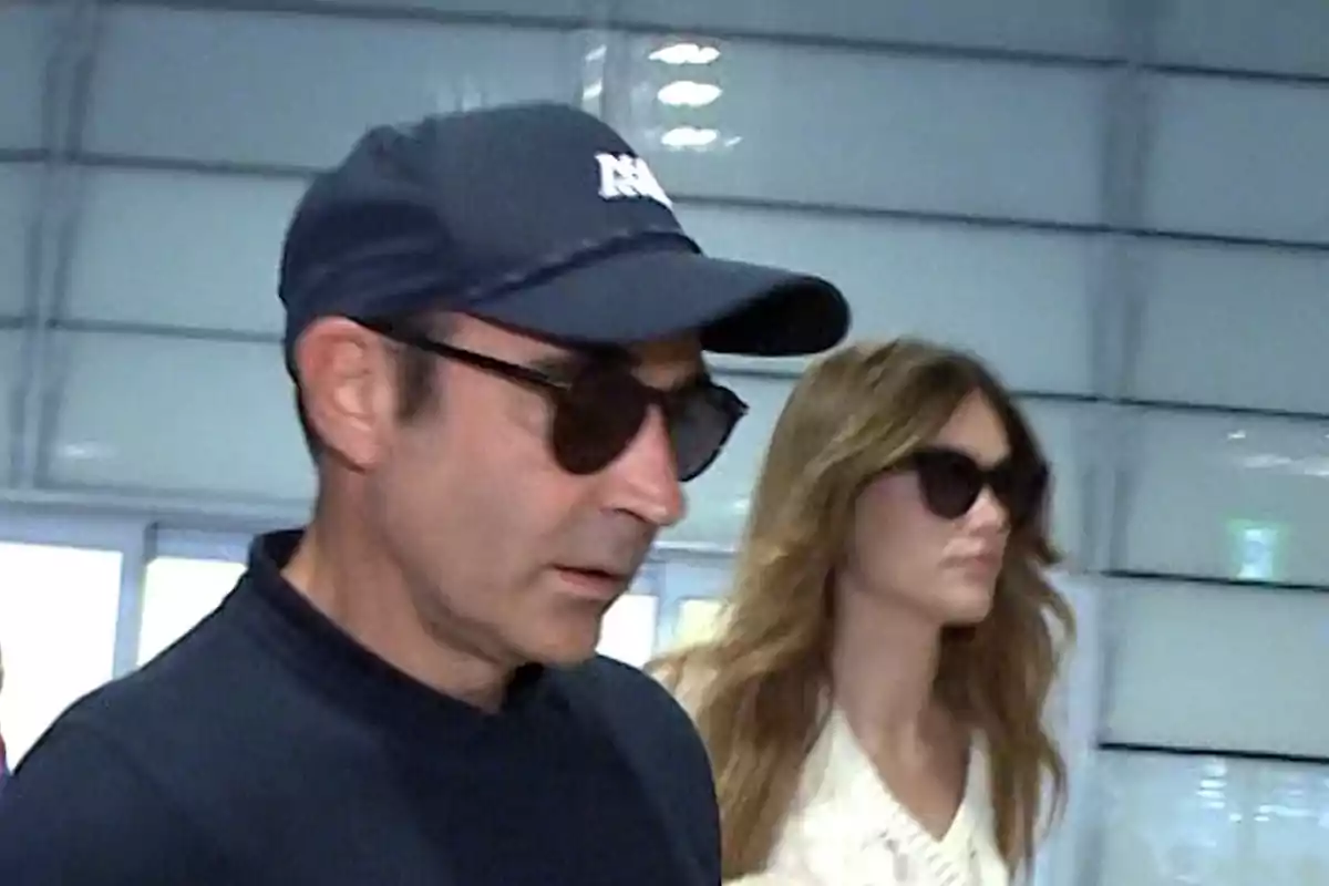 Enrique Ponce y Ana Soria con gafas de sol y ropa casual caminan en un entorno interior. Enrique Ponce y Ana Soria con gafas de sol y ropa casual caminan en un entorno interior.