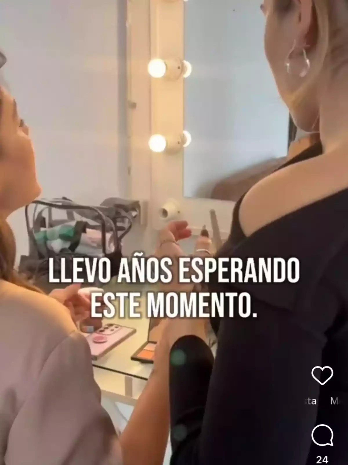 Fabiola Martínez y su maquilladora frente a un espejo iluminado, una de ellas sostiene productos de maquillaje. Fabiola Martínez y su maquilladora frente a un espejo iluminado, una de ellas sostiene productos de maquillaje.