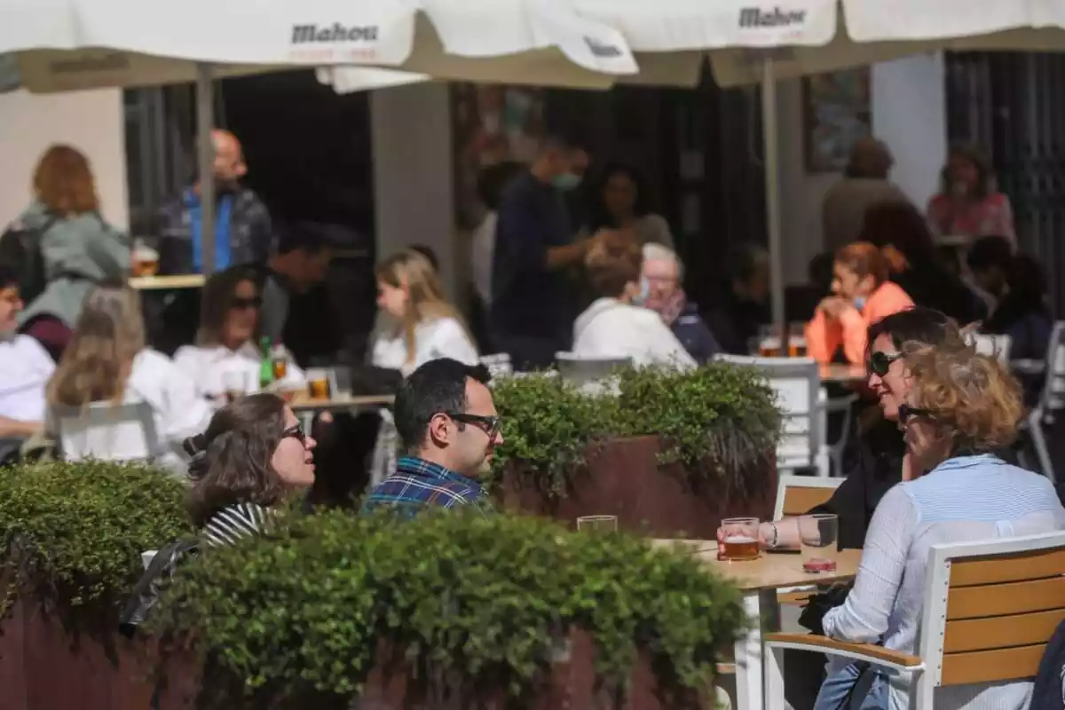 Imagen de varias personas sentadas en la terraza de un bar en otoño