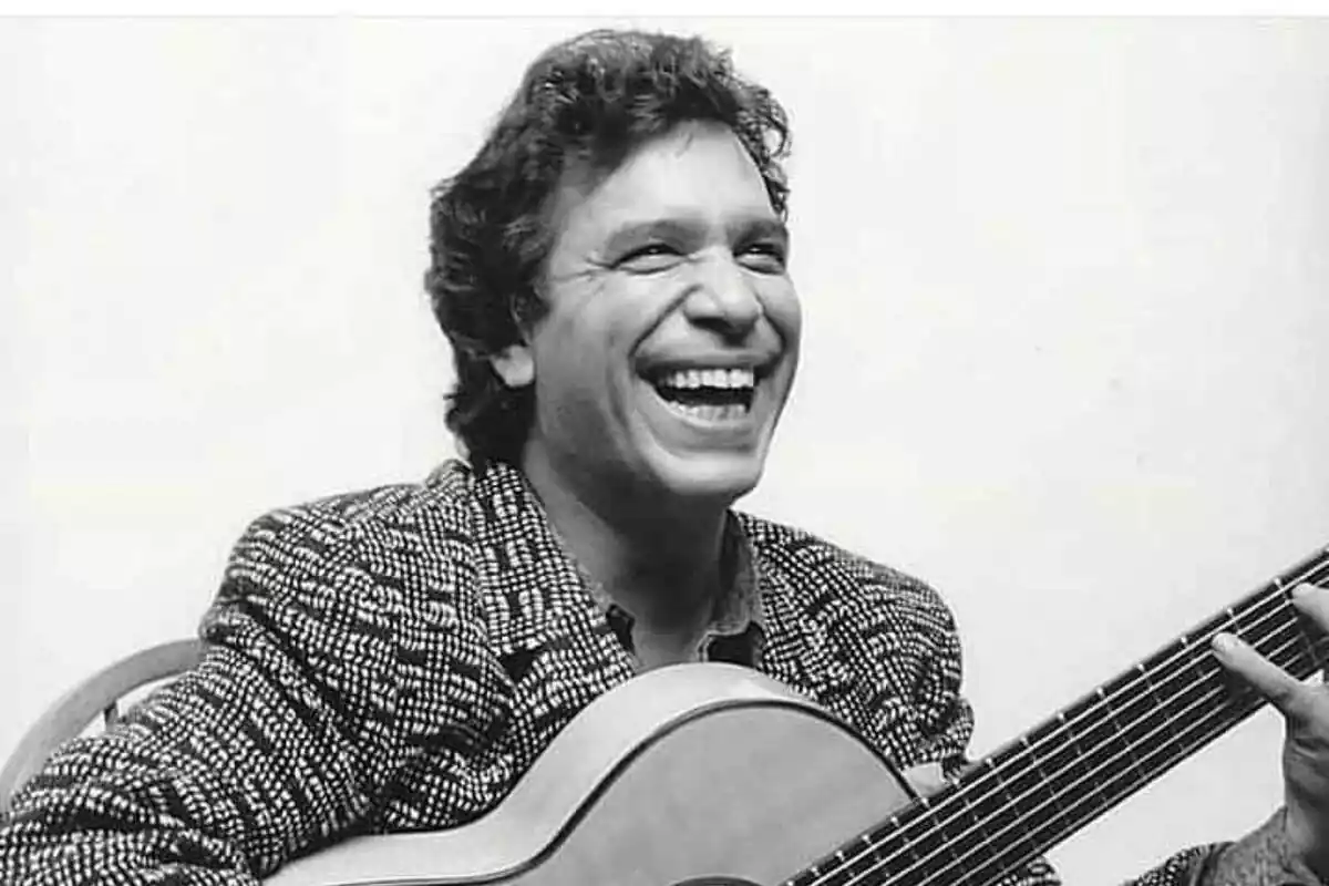 Imagen de Joaquín Amador de joven sonriendo y posando con una guitarra