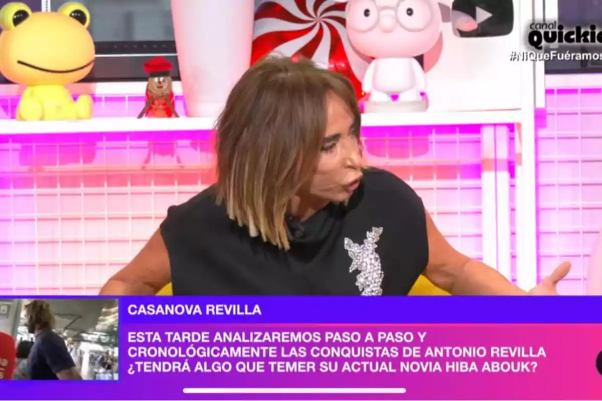 María Patiño hablando en un programa de televisión con un fondo colorido y varios objetos decorativos. María Patiño hablando en un programa de televisión con un fondo colorido y varios objetos decorativos.