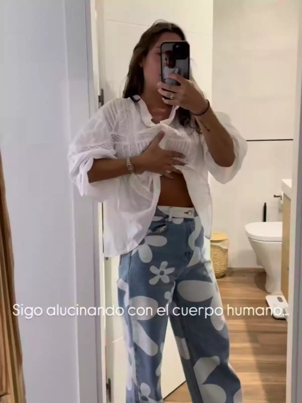 Marta Pombo se toma una selfie frente a un espejo, levantando su blusa para mostrar su abdomen, con la frase Marta Pombo se toma una selfie frente a un espejo, levantando su blusa para mostrar su abdomen, con la frase