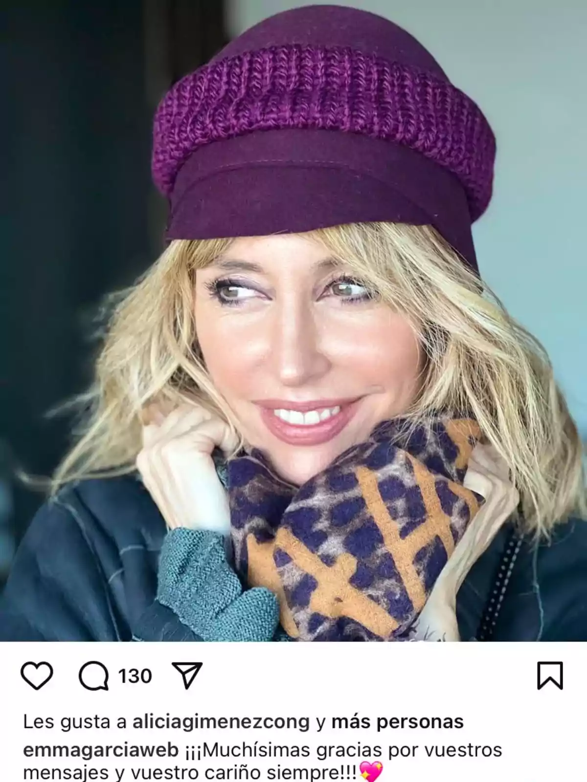 Emma García con gorro morado y bufanda estampada sonríe mientras mira hacia un lado. Emma García con gorro morado y bufanda estampada sonríe mientras mira hacia un lado.