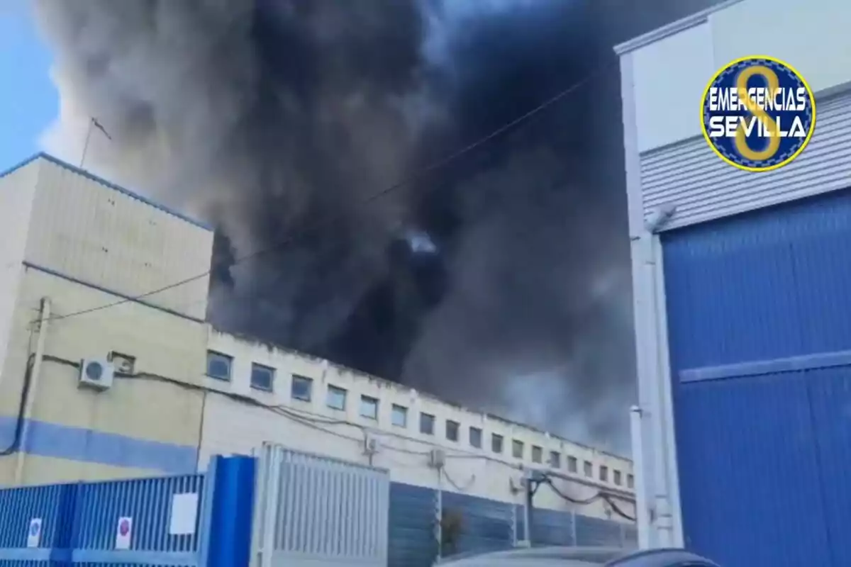 Un edificio industrial con humo negro saliendo del techo y un logotipo de Un edificio industrial con humo negro saliendo del techo y un logotipo de