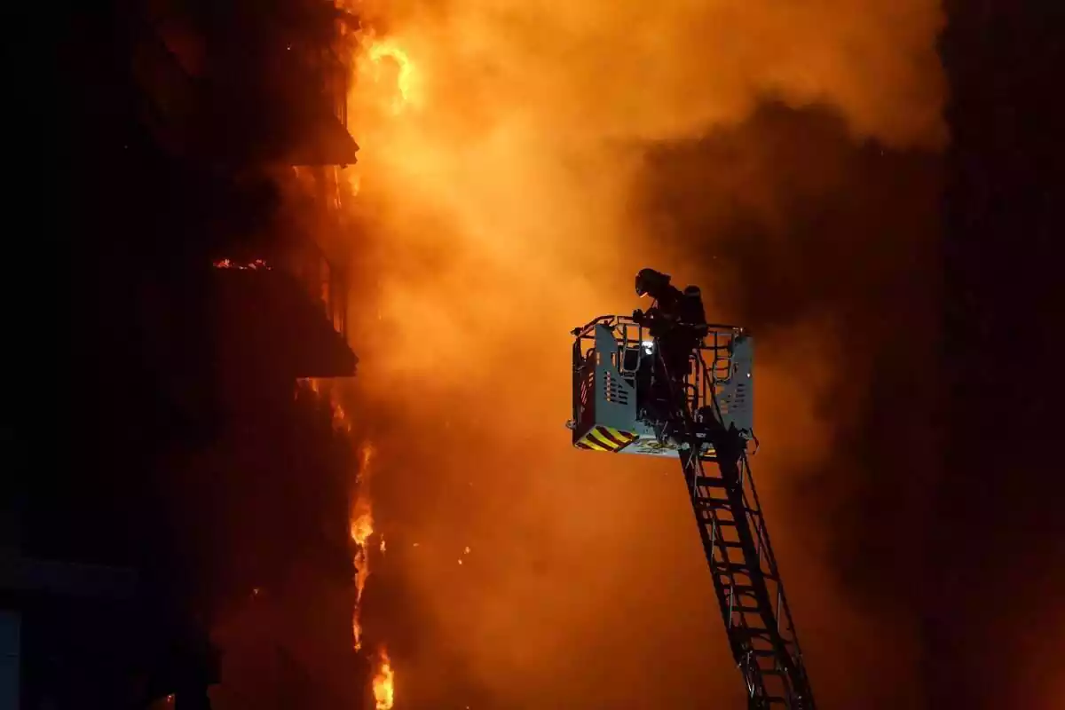 Un bombero apagando el incendio de Valencia