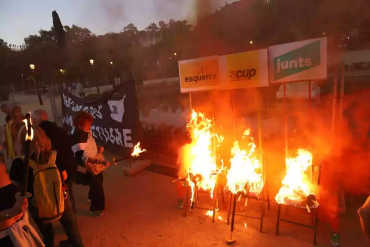 Imagen de un grupo de radicales independentistas quemando carteles de partidos políticos