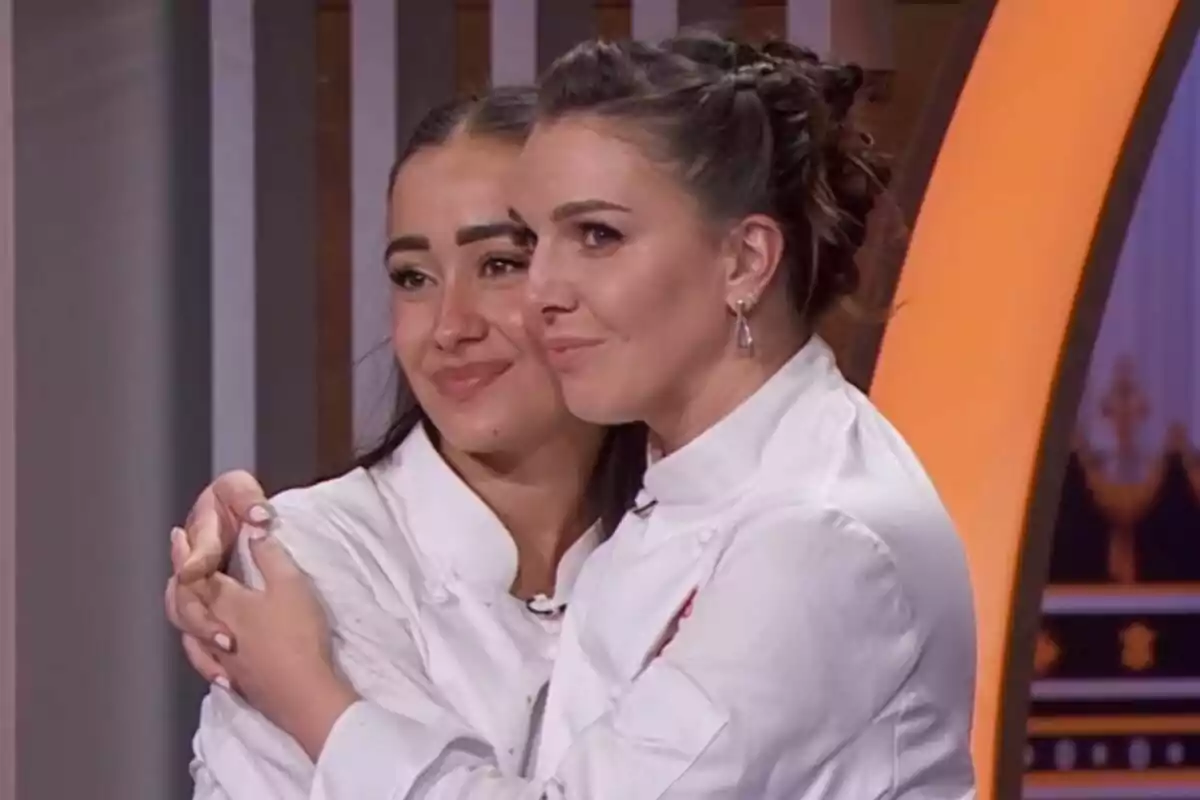 Inés Hernand y Marina Rivers con chaquetas blancas de chef se abrazan y sonríen en un ambiente interior en MasterChef Celebrity.