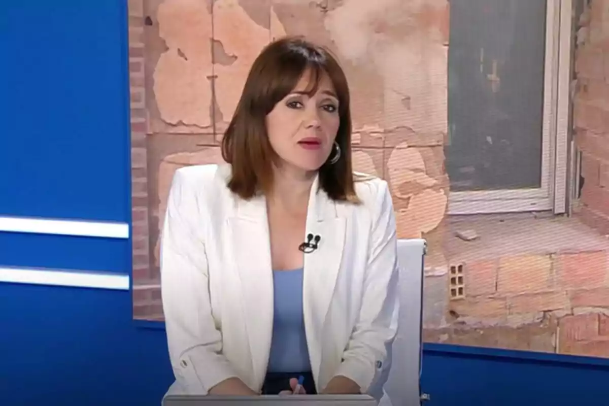 Inma Canet de cabello castaño y liso con chaqueta blanca y blusa azul sentada en un estudio de televisión del Informativo Territorial de RTVE en Valencia con fondo de pared de ladrillos y pantalla azul Inma Canet de cabello castaño y liso con chaqueta blanca y blusa azul sentada en un estudio de televisión del Informativo Territorial de RTVE en Valencia con fondo de pared de ladrillos y pantalla azul