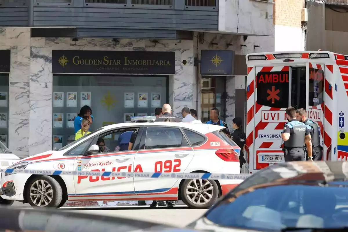 Policia y ambulancia de Gijón delante de la inmobiliaria donde murió un hombre