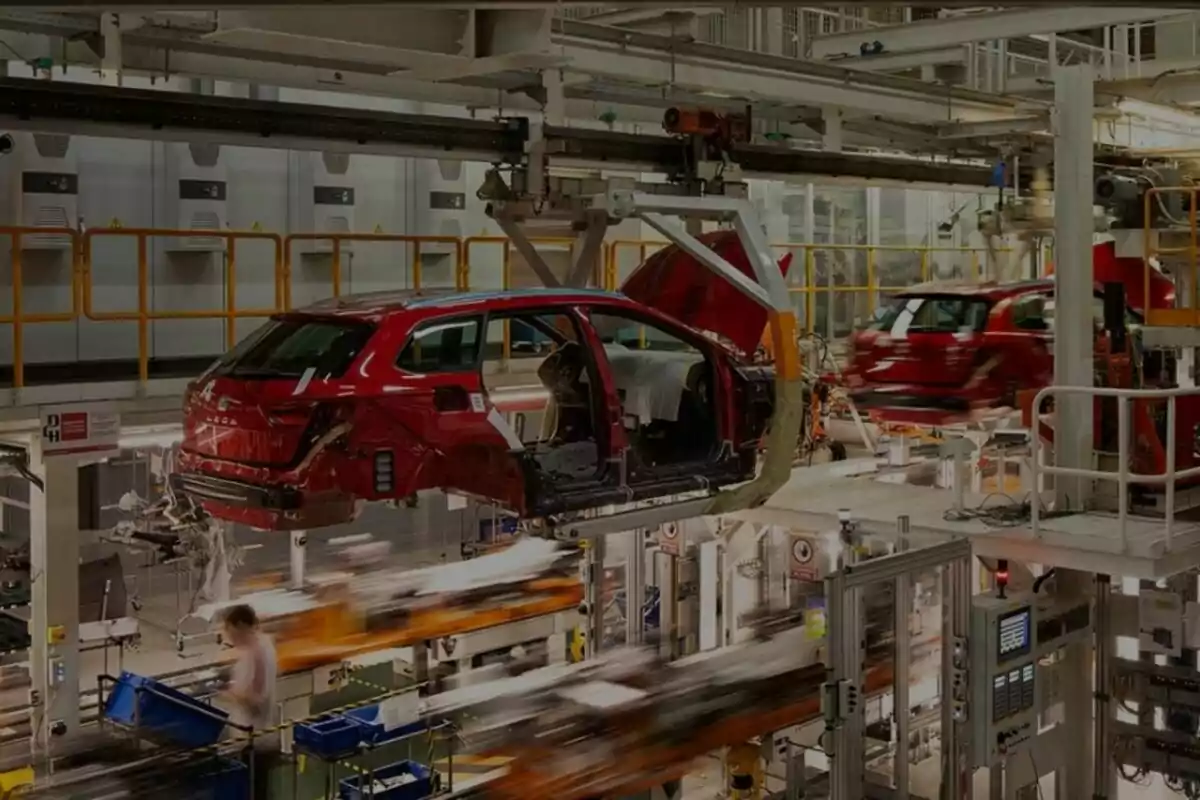 Línea de ensamblaje de automóviles en una fábrica con carrocerías de coches rojos en proceso de montaje. Línea de ensamblaje de automóviles en una fábrica con carrocerías de coches rojos en proceso de montaje.