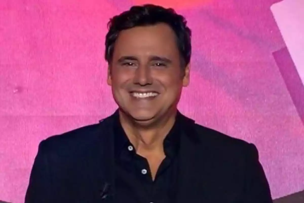 Ion Aramendi sonriendo con fondo rosa en el debate de Gran Hermano.