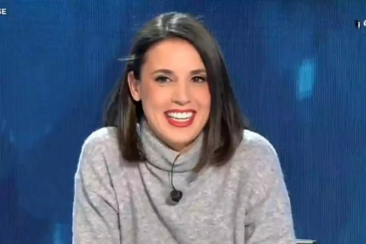 Irene Montero sonriendo en Todo es Mentira con un suéter gris y un micrófono de solapa. Irene Montero sonriendo en Todo es Mentira con un suéter gris y un micrófono de solapa.