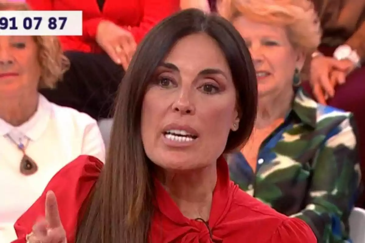 Isabel Rábago con cabello largo y oscuro está hablando en Y ahora Sonsoles, vestida con una blusa roja, mientras otras personas están sentadas detrás de ella.