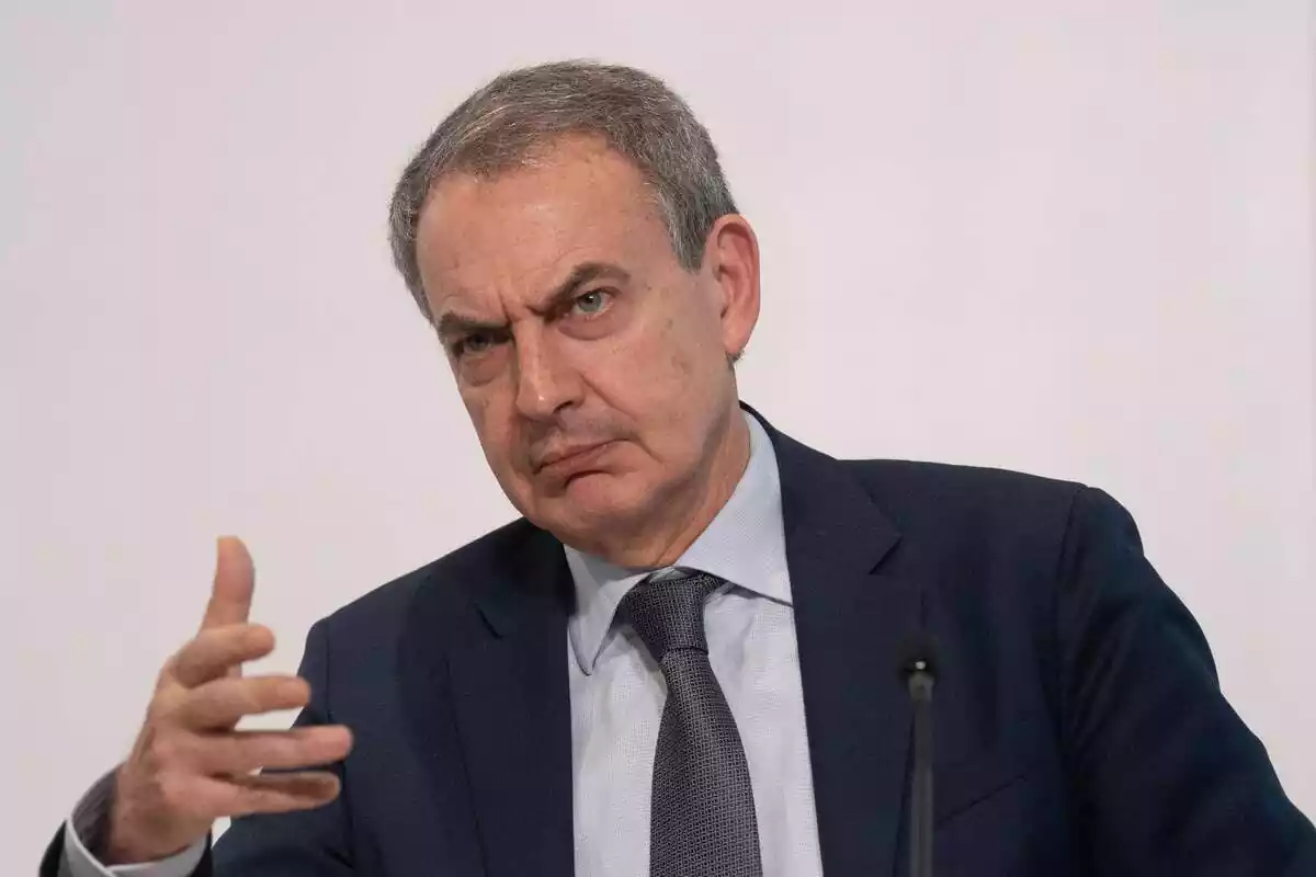 Plano medio de José Luis Rodríguez Zapatero haciendo cara de enfadado mientras hace gestos con su mano derecha