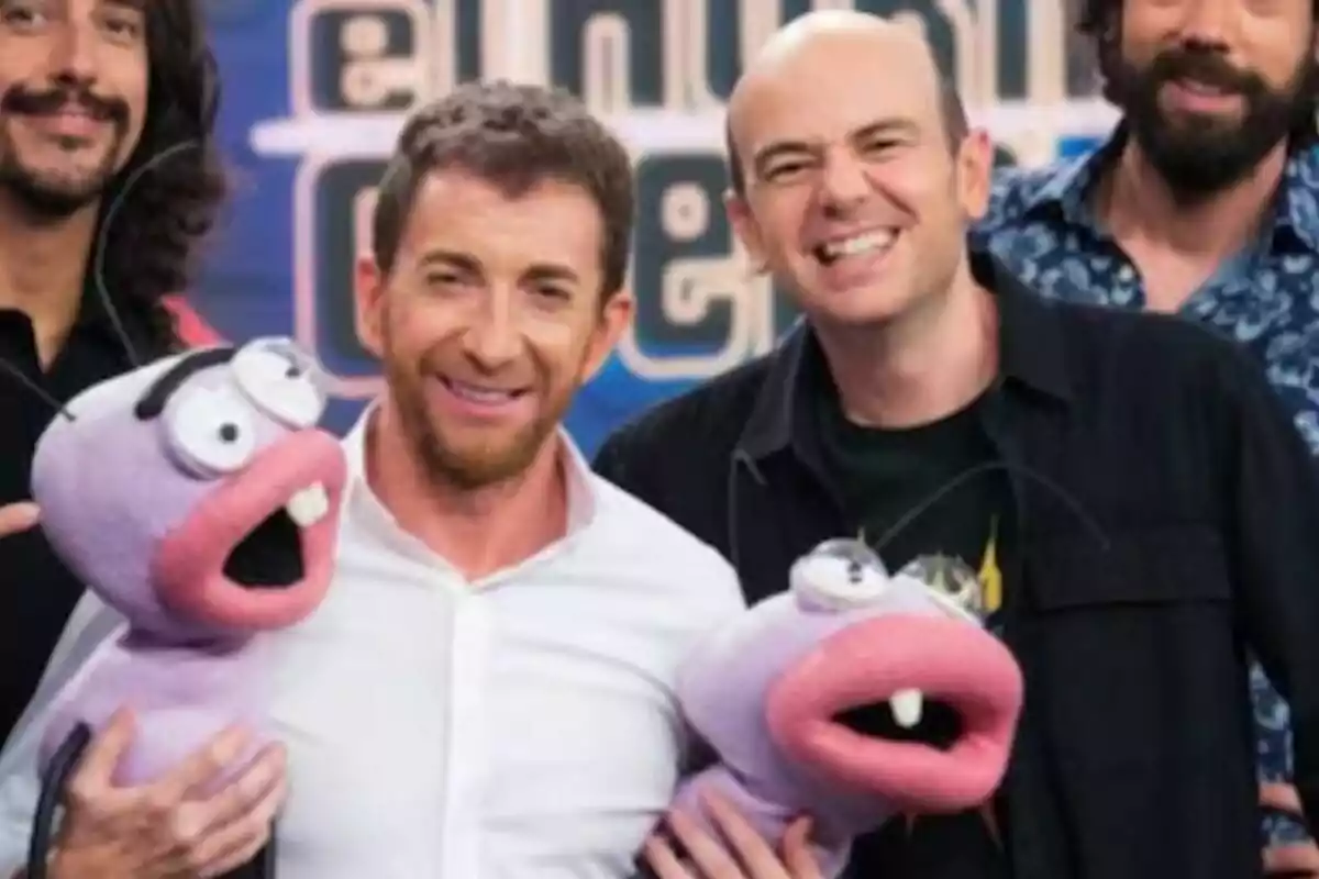 Jandro junto a Pablo Motos sonríe mientras sostiene marionetas de color morado con grandes ojos y bocas abiertas en El Hormiguero.