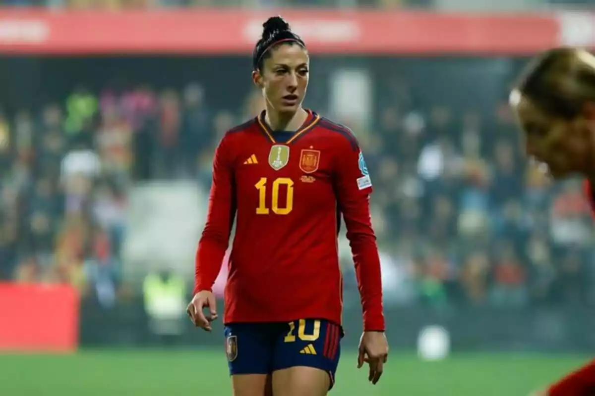 Una jugadora de fútbol con el uniforme rojo de la selección de España en el campo de juego. Una jugadora de fútbol con el uniforme rojo de la selección de España en el campo de juego.