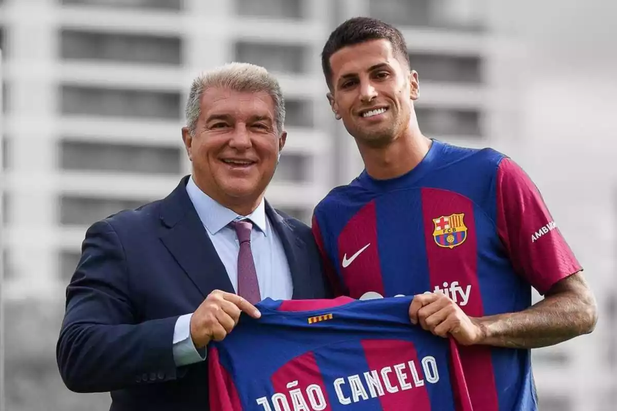 Joan Laporta posa junto a Joao Cancelo sujetando una camiseta del FC Barcelona