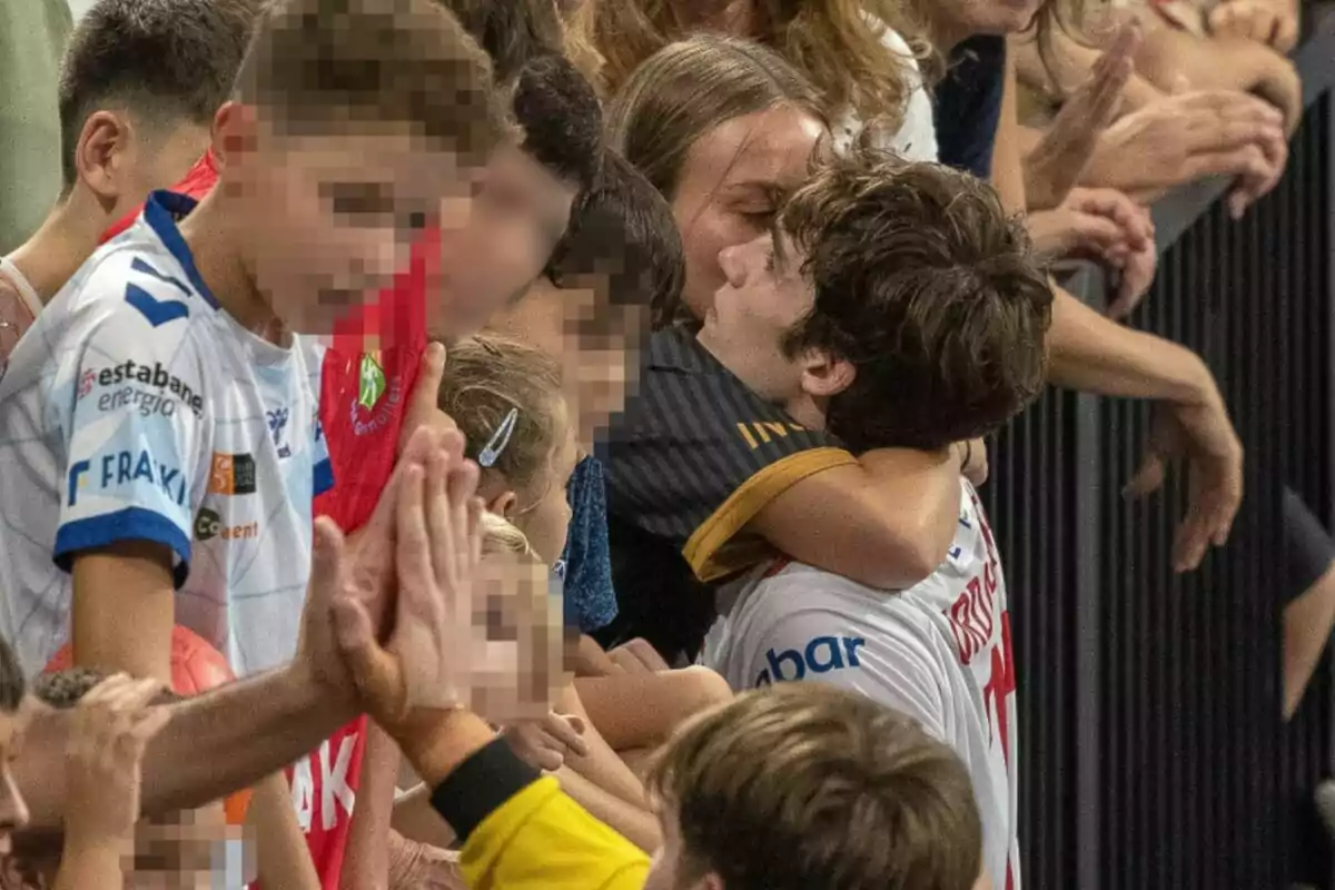 Un grupo de personas en una multitud, Johanna Zott y Pablo Urdangarin abrazándose y otras chocando las manos, con rostros pixelados. Un grupo de personas en una multitud, Johanna Zott y Pablo Urdangarin abrazándose y otras chocando las manos, con rostros pixelados.